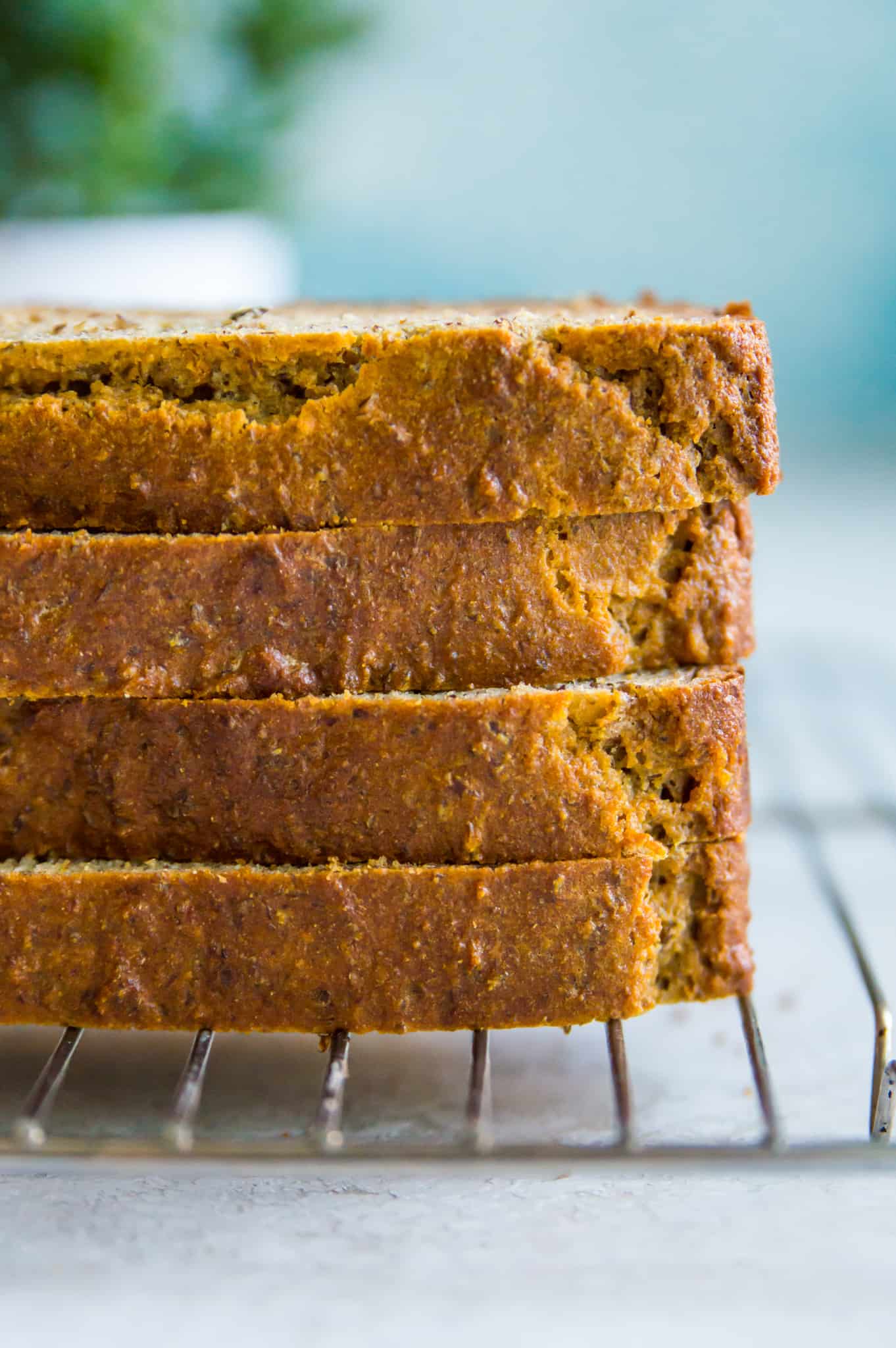 A sliced loaf of bread stacked on a baking rack.