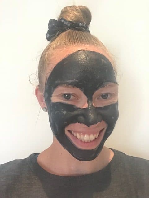 A girl with the Beautycounter charcoal mask on her face. 