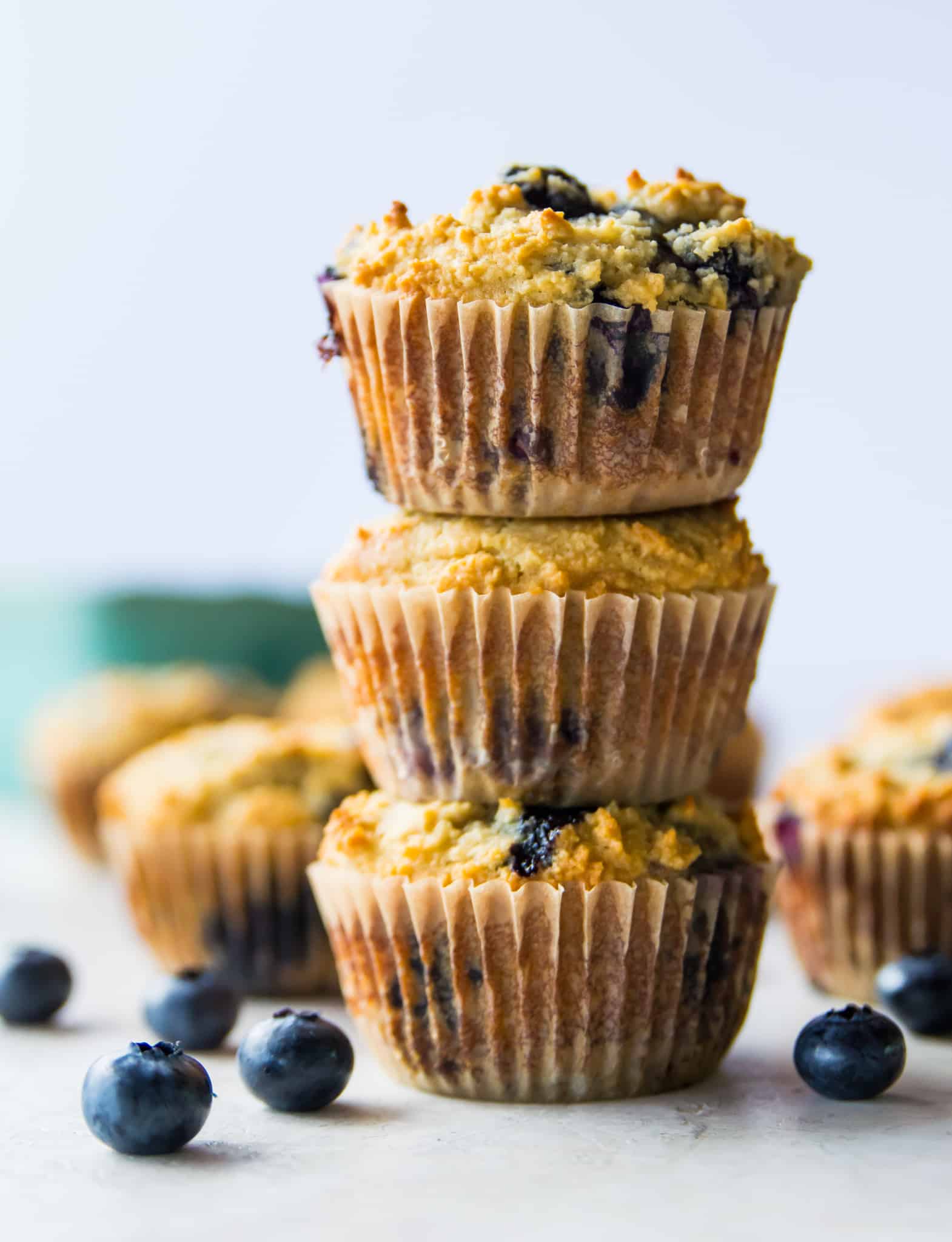 A stack of three paleo lemon blueberry muffins. 