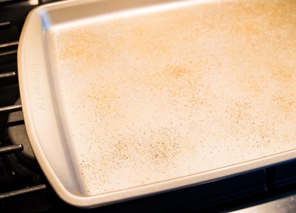 A baking sheet with salt and pepper on it.