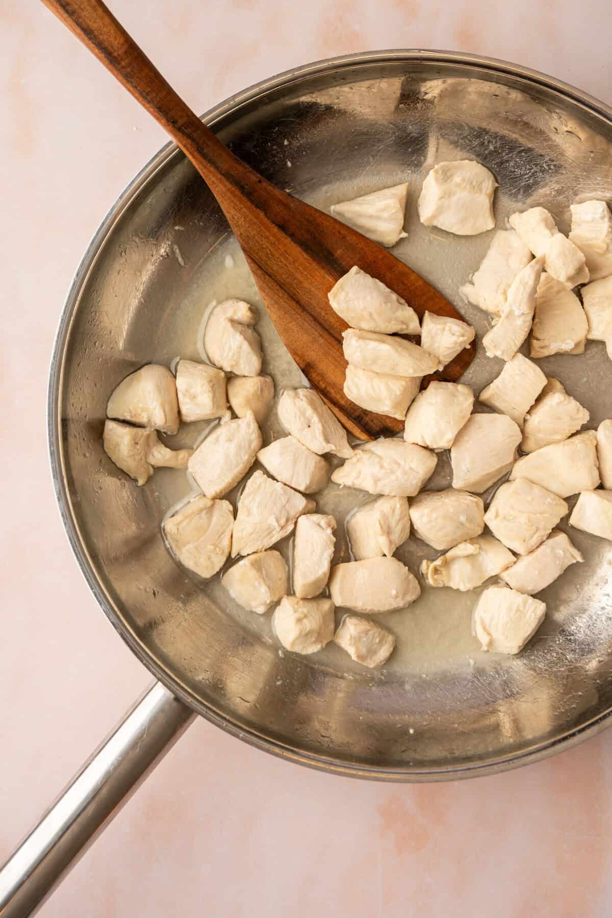 Chopped chicken cooking in a pan. 