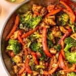 A pan filled with chicken and vegetable stir fry.