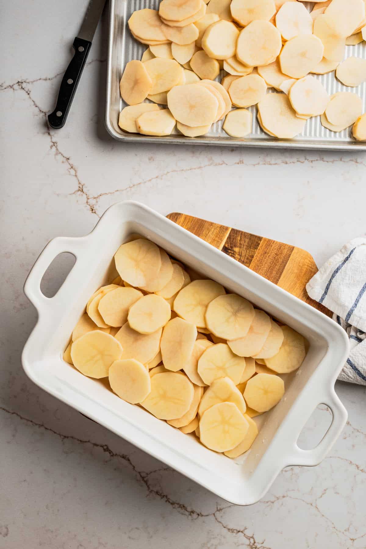 A casserole dish filled with thinly sliced potatoes. 