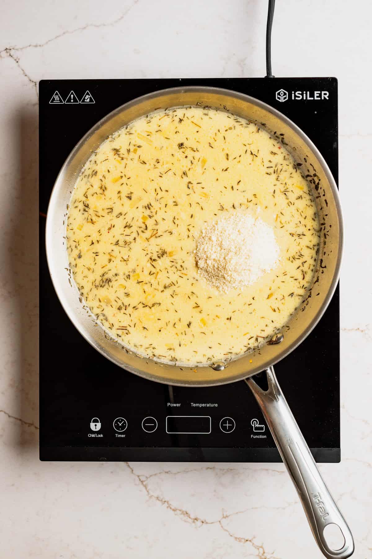 A pot with a creamy liquid in it with almond flour on top of the liquid.
