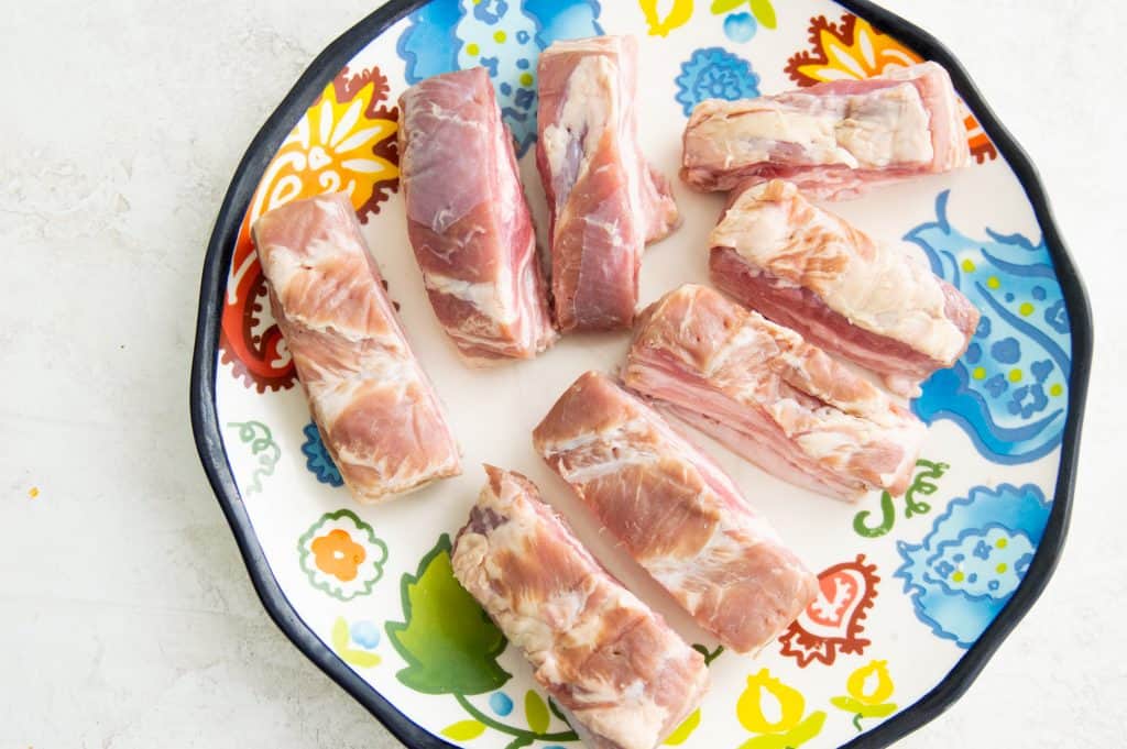 Pork belly strips on a plate.
