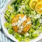 A cooked salmon cake on a bed of lettuce