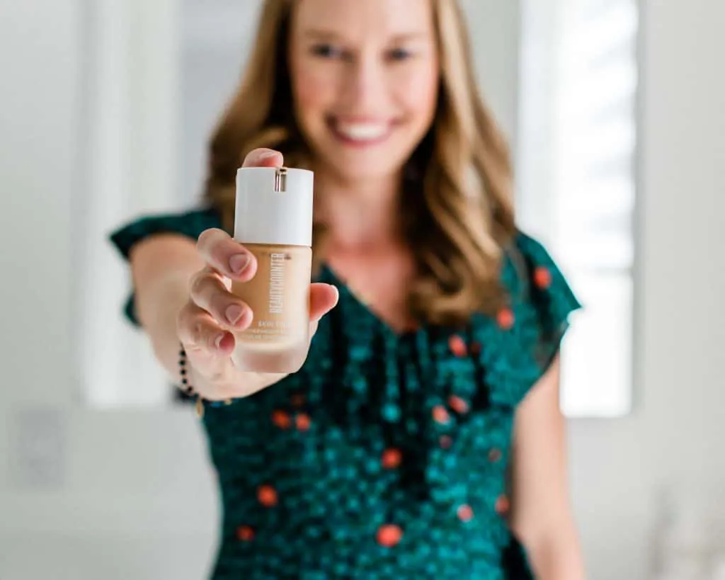 A girl holding a bottle of Beautycounter foundation