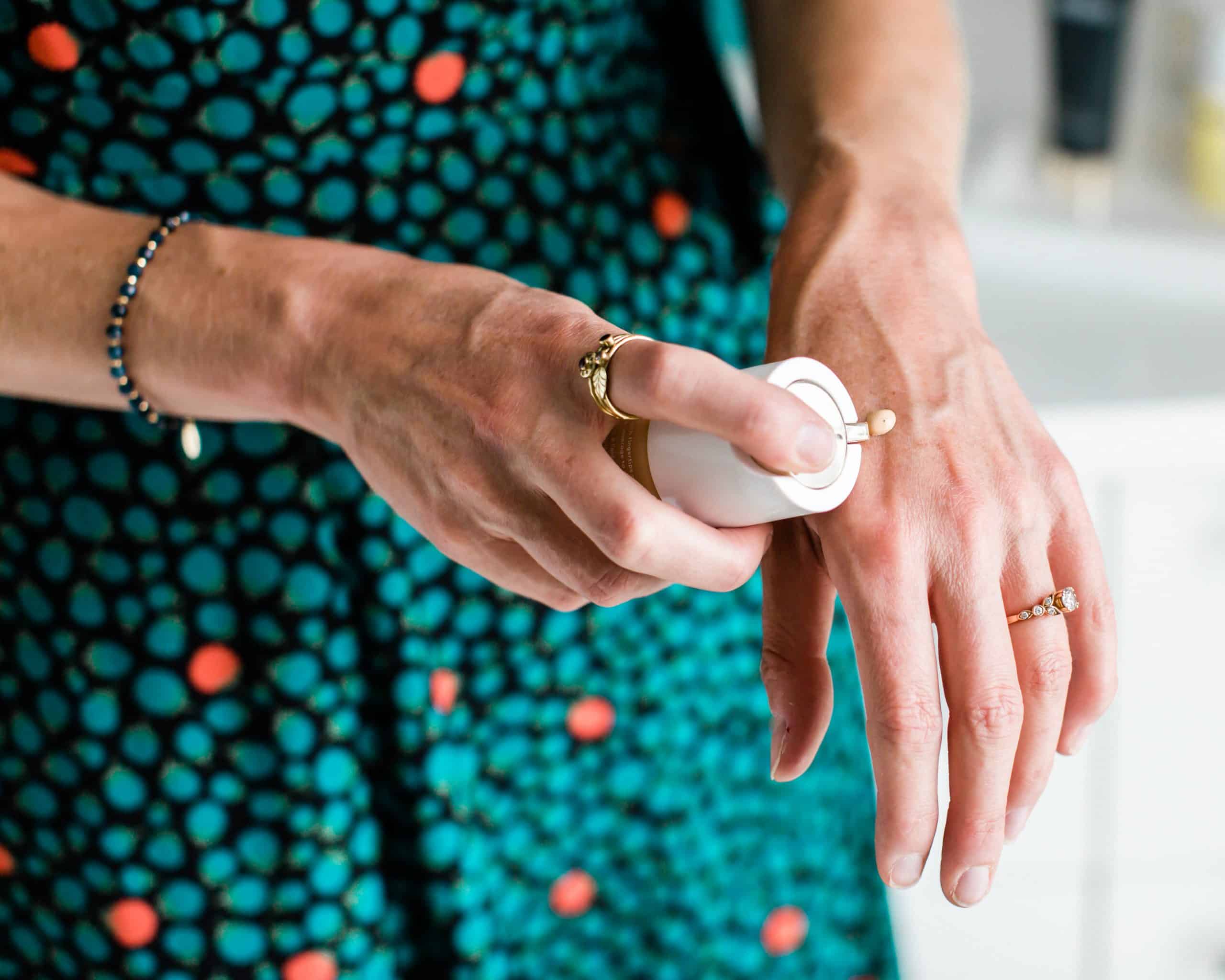 A girl putting a pump of Beautycounter foundation on the back of her hand.
