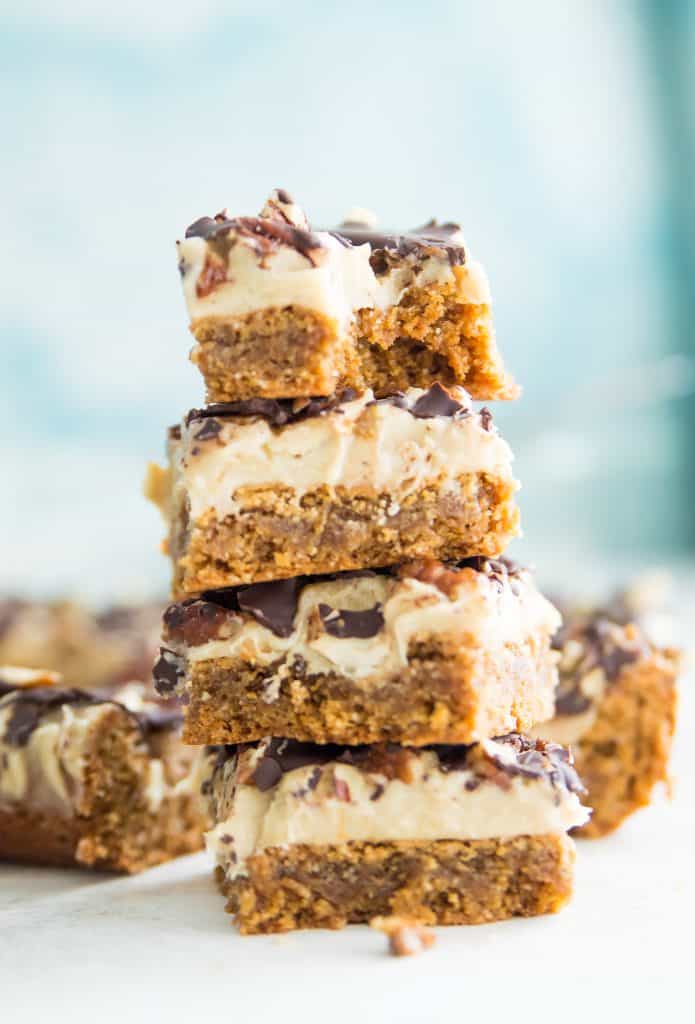 A stack of 4 turtle dessert bars and the top one has a bite out of it.