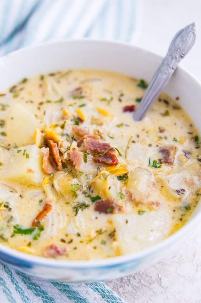 A bowl of dairy free clam chowder with a silver spoon in it