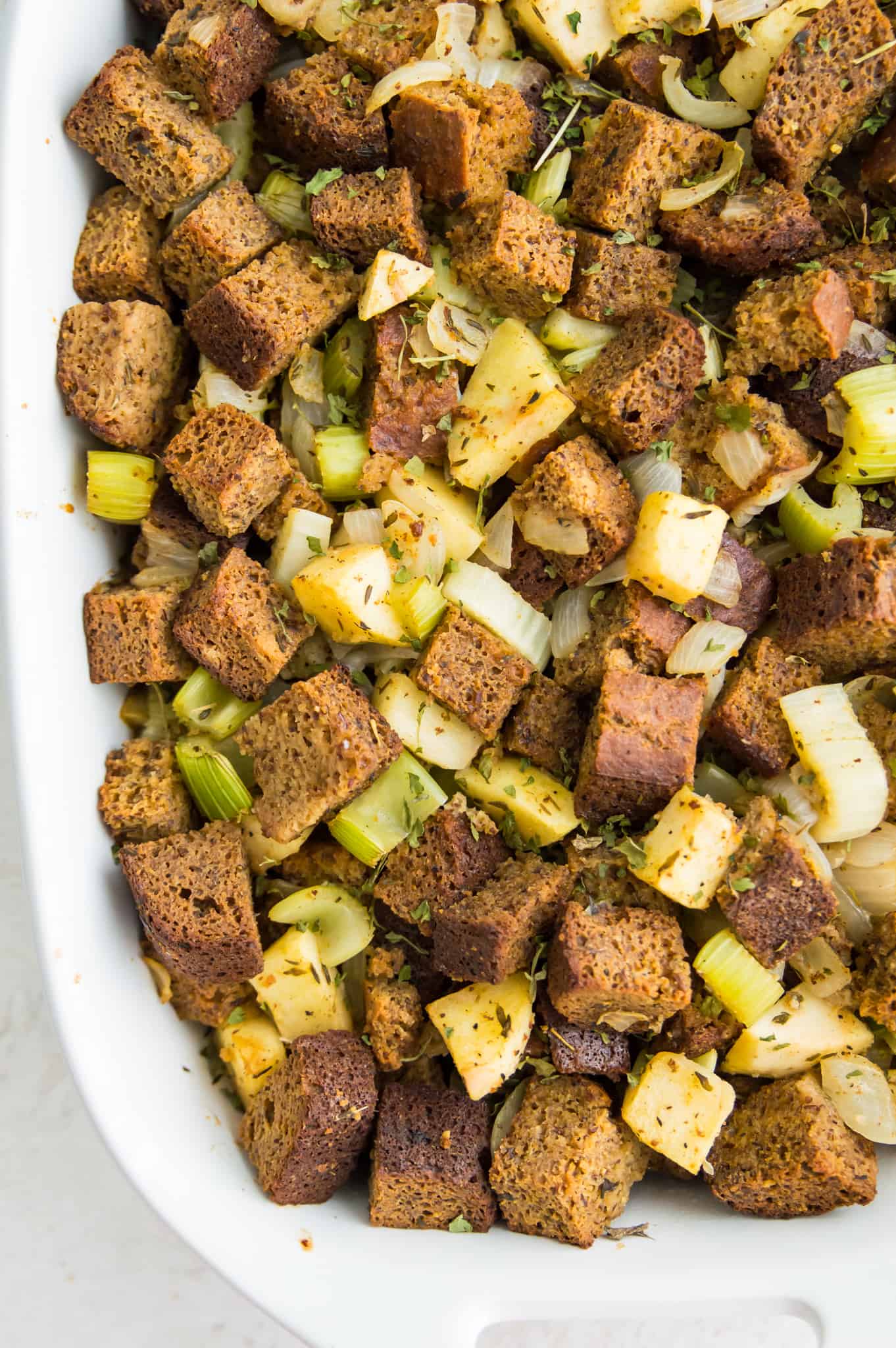 A casserole dish filled with paleo stuffing with onions, ales and spices.