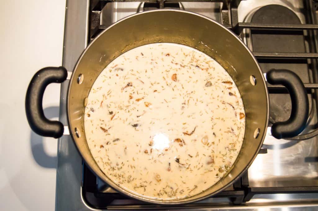 A large pot of cream of mushroom soup cooking on the stovetop.