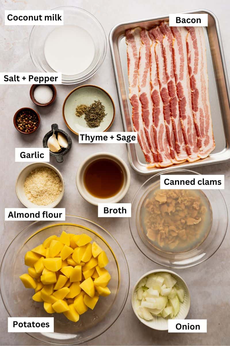 The ingredients needed to make clam chowder including bacon, chopped potatoes, broth, coconut milk, onion, garlic and canned clams.