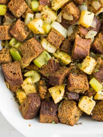 A casserole dish filled with paleo stuffing with chopped apples and celery in it.