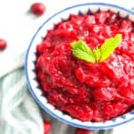 A bowl of sugar free cranberry sauce with mint leaves on top for garnish.