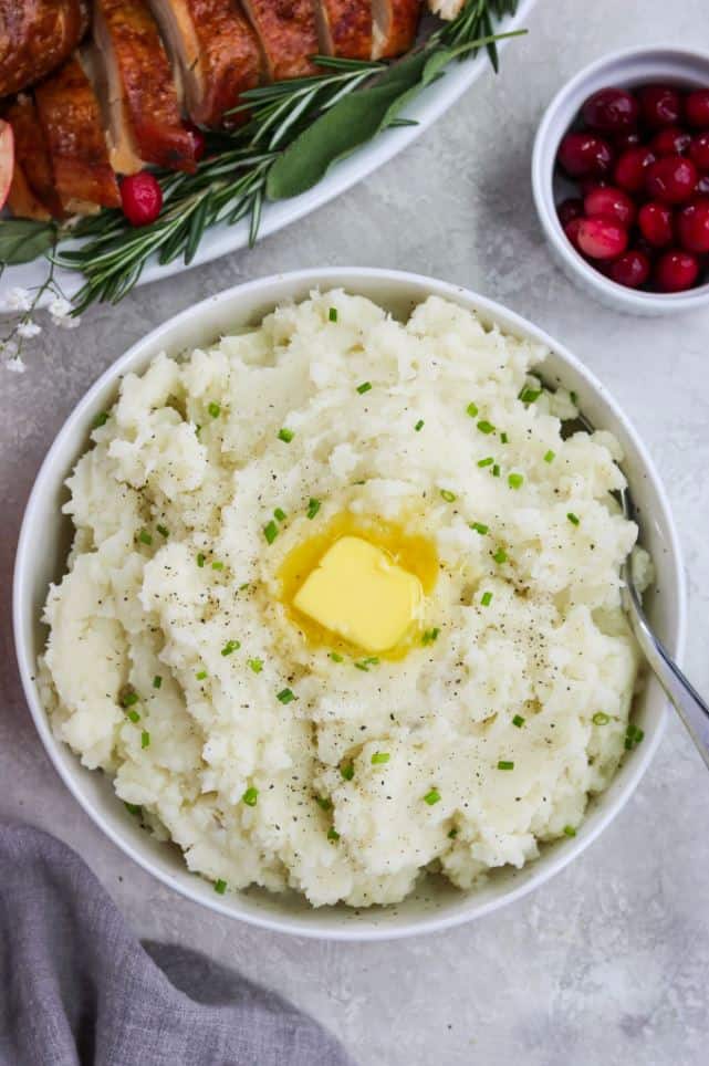 A bowl of paleo creamy Whole30 mashed potatoes topped with vegan butter.