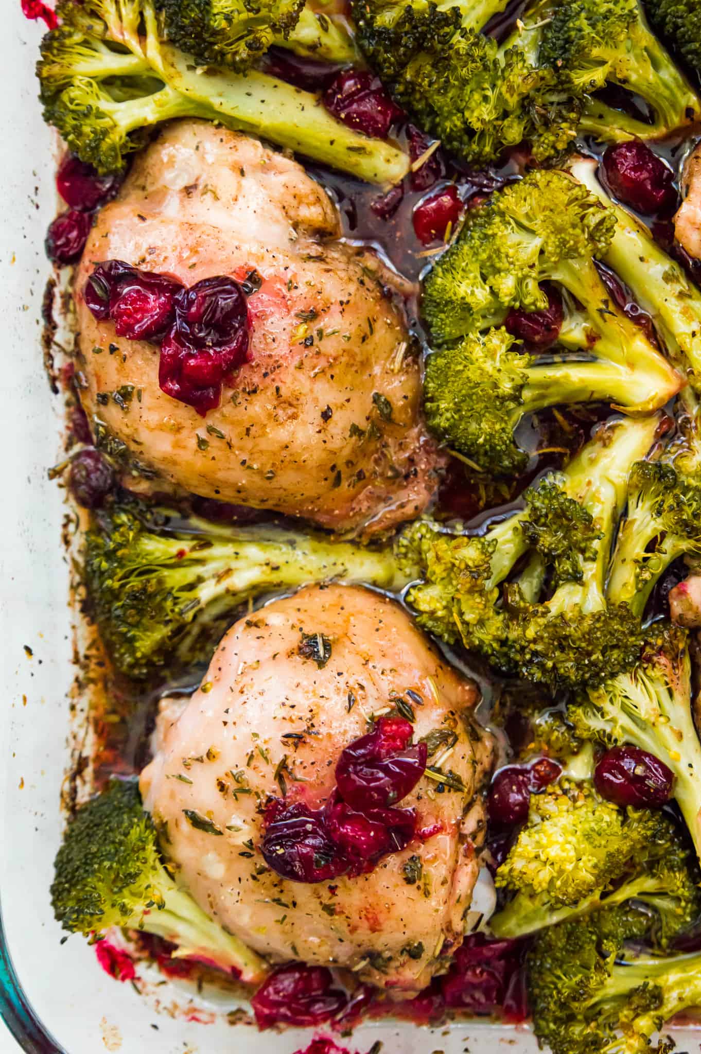 A pan full of cranberry maple chicken and broccoli with cranberries on top for garnish.