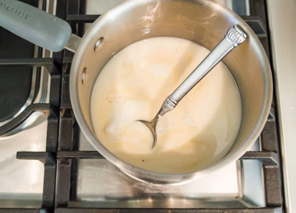 Melted white chocolate in a pot on the stovetop.