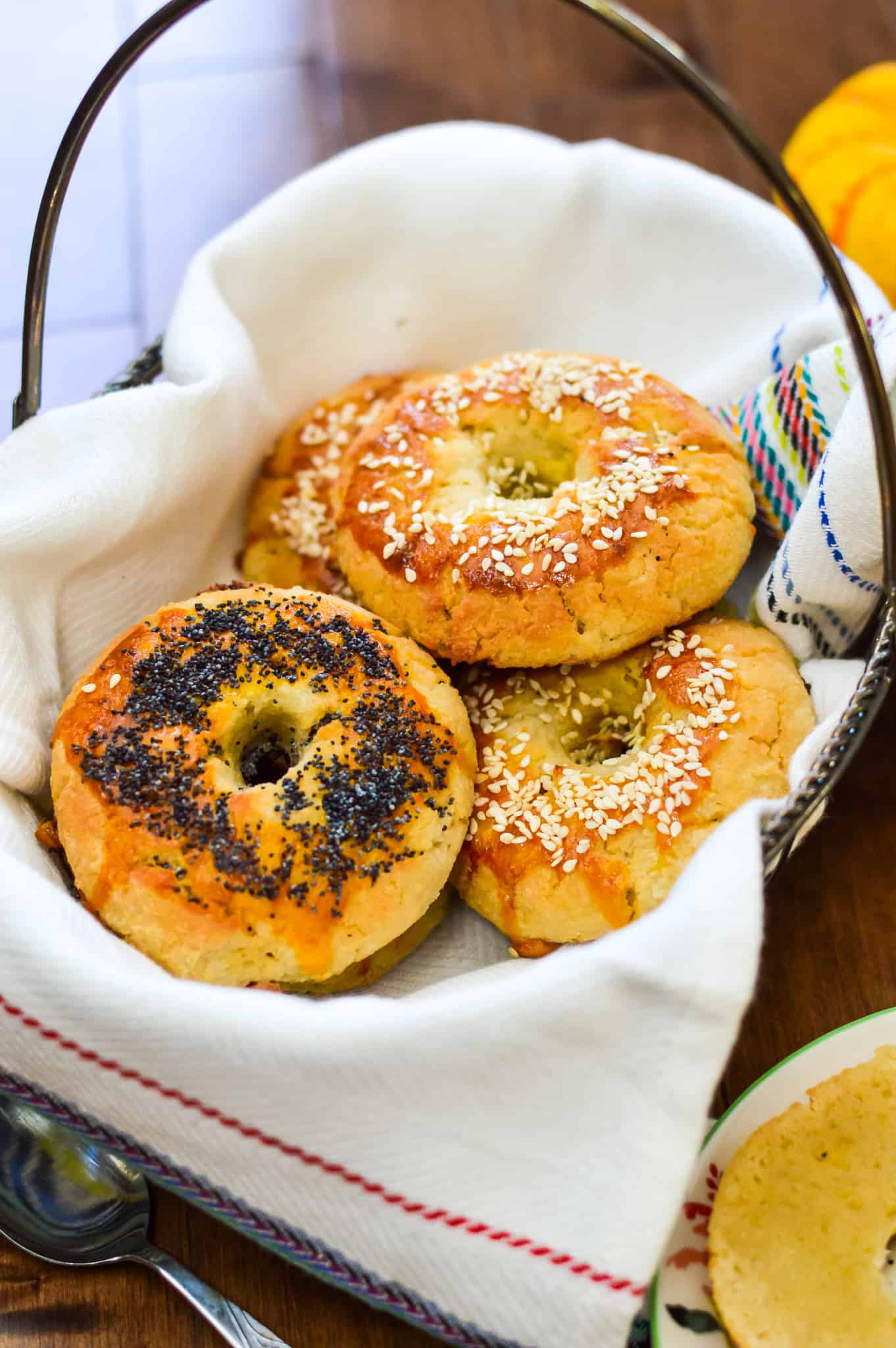A basket full of paleo bagels topped with sesame seeds.