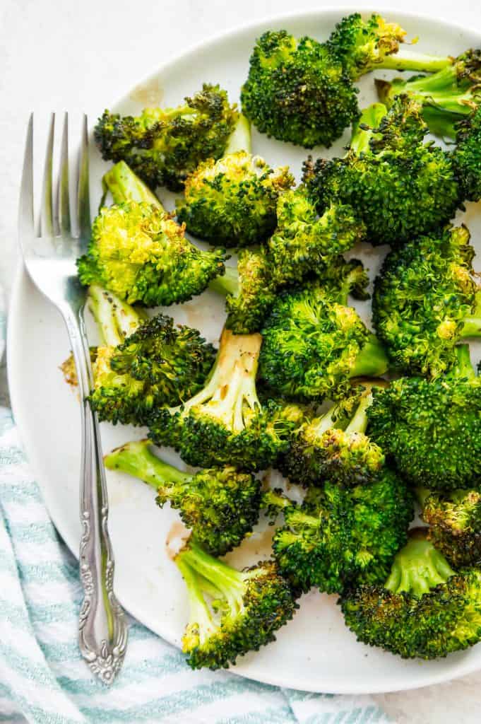 A plate of air fryer broccoli with a silver fork