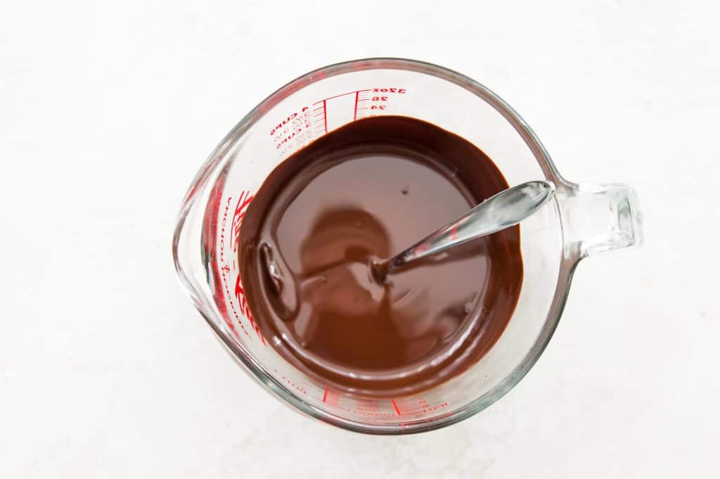 A glass measuring cup with melted chocolate in it.