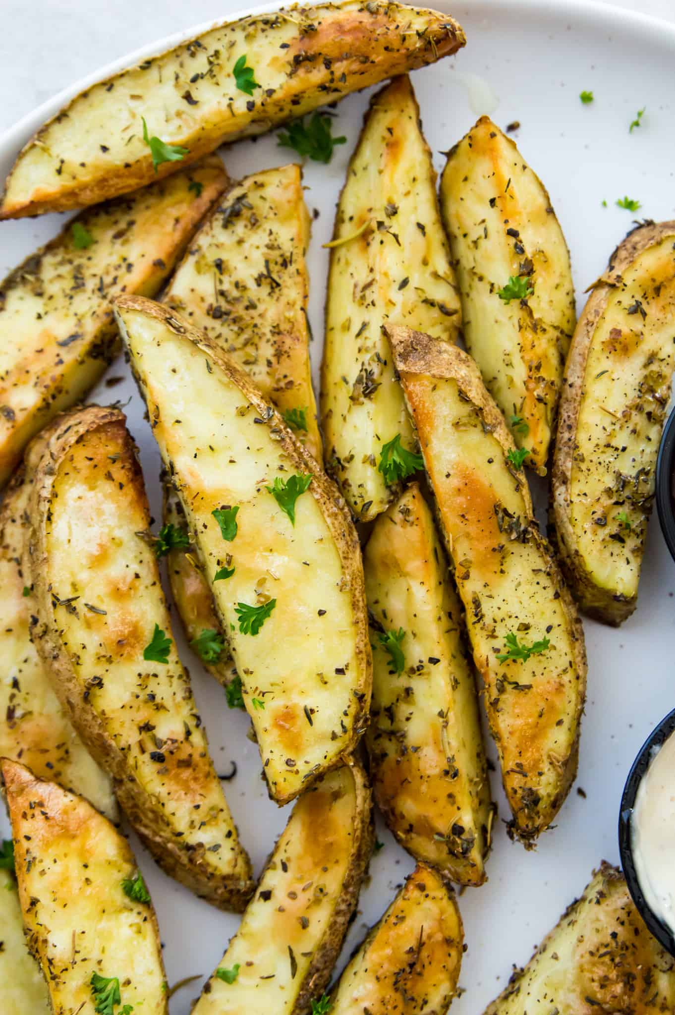 A plate of homemade potato wedges seasoned with fresh parsley .