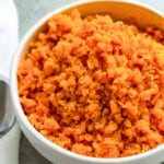 A bowl of cooked sweet potato rice topped with black pepper.