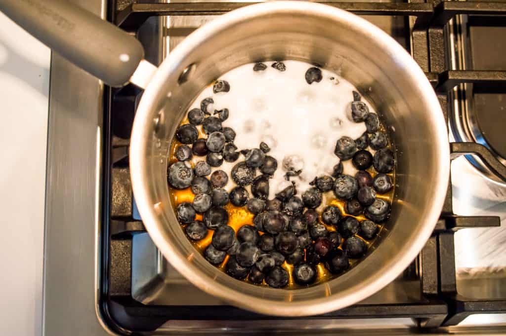 Blueberries and coconut milk in a pot on the stovetop.