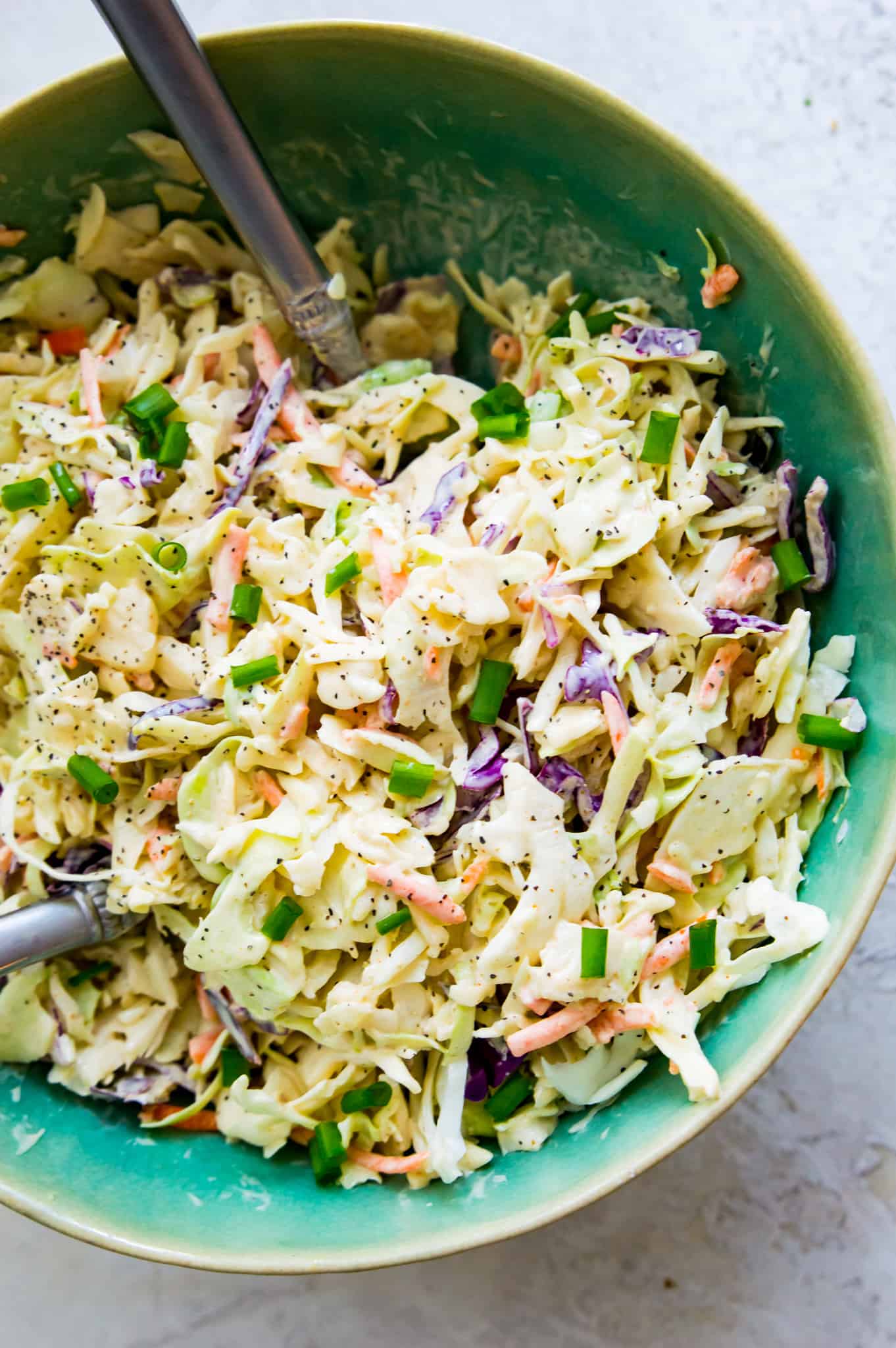 Keto Coleslaw Recipe A bowl of keto coleslaw with spoons in it.
