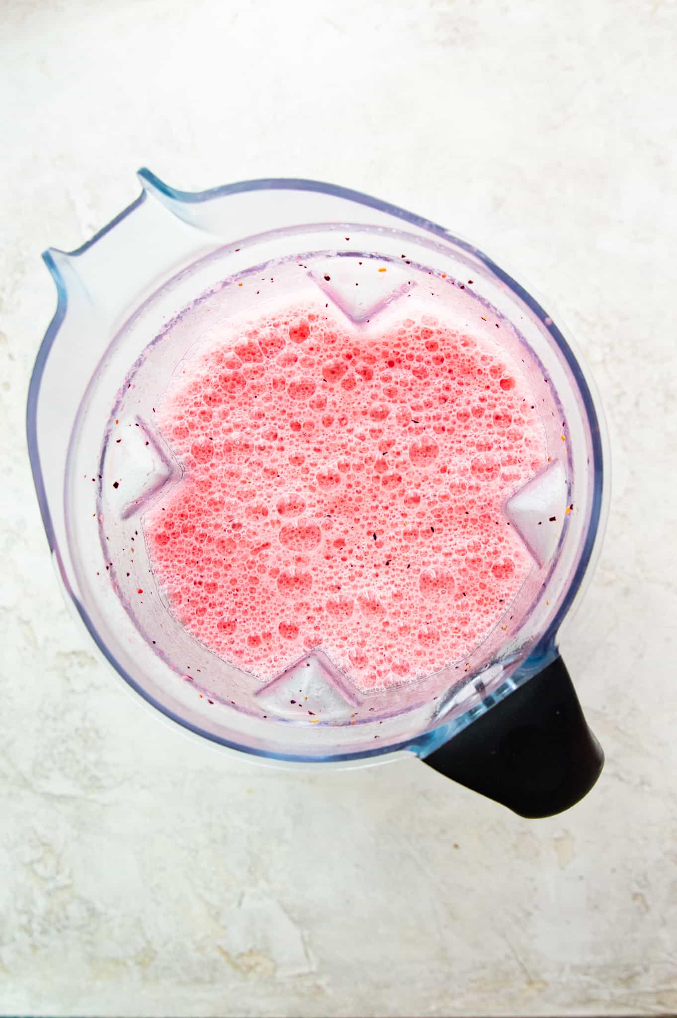 A blender full of a pink smoothie.