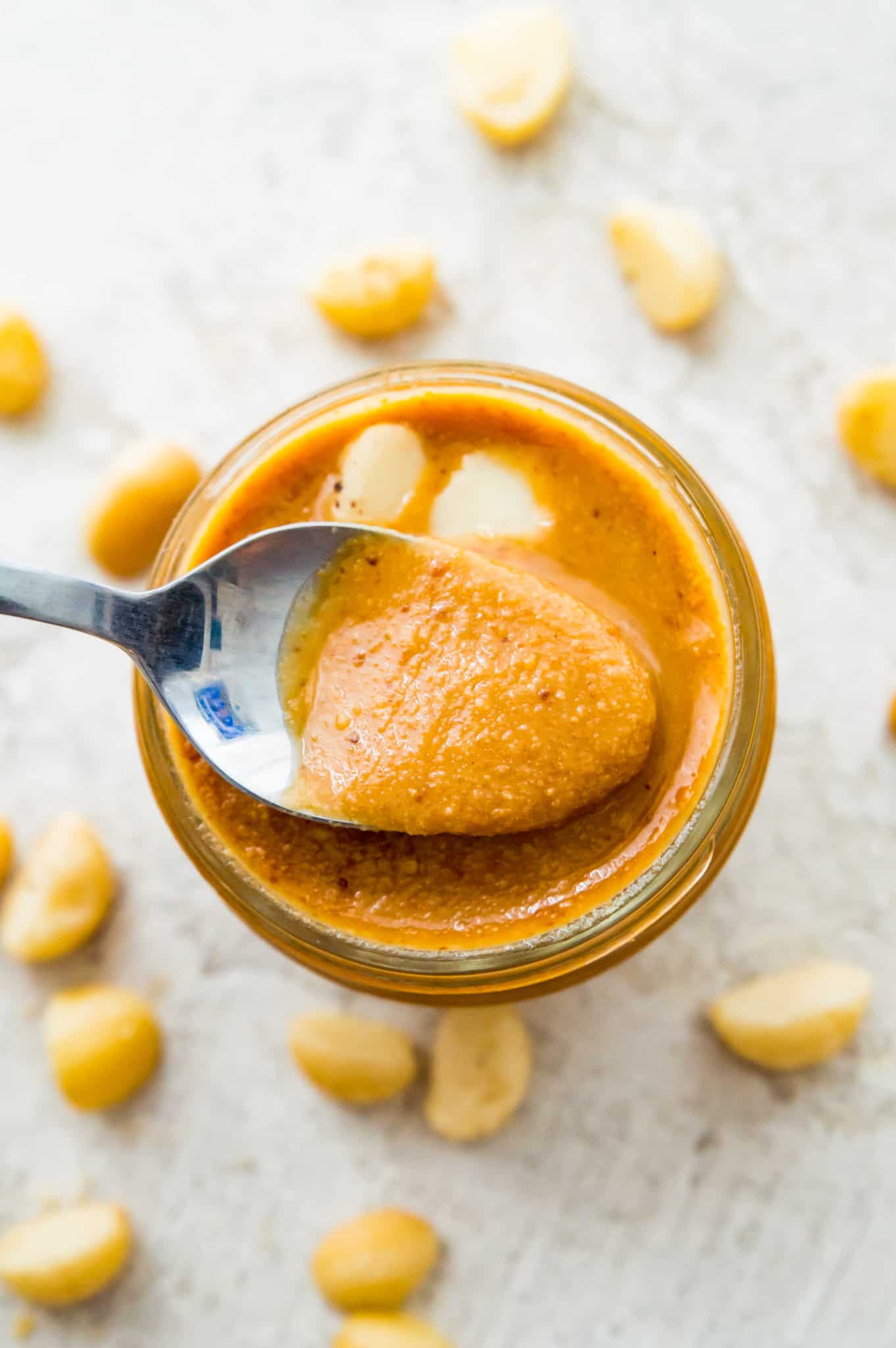 A jar of macadamia nut butter with a spoon in it.