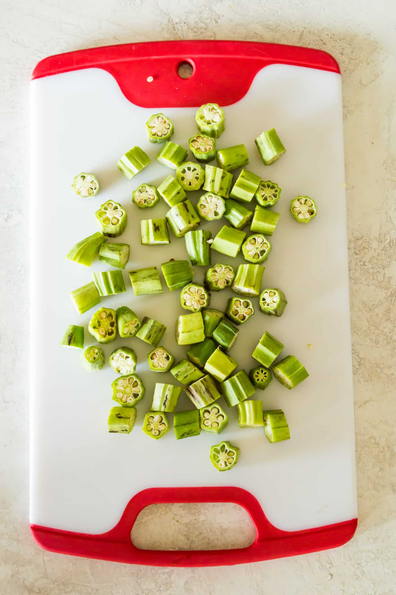 Chopped pieces of fresh okra on a cutting board. 