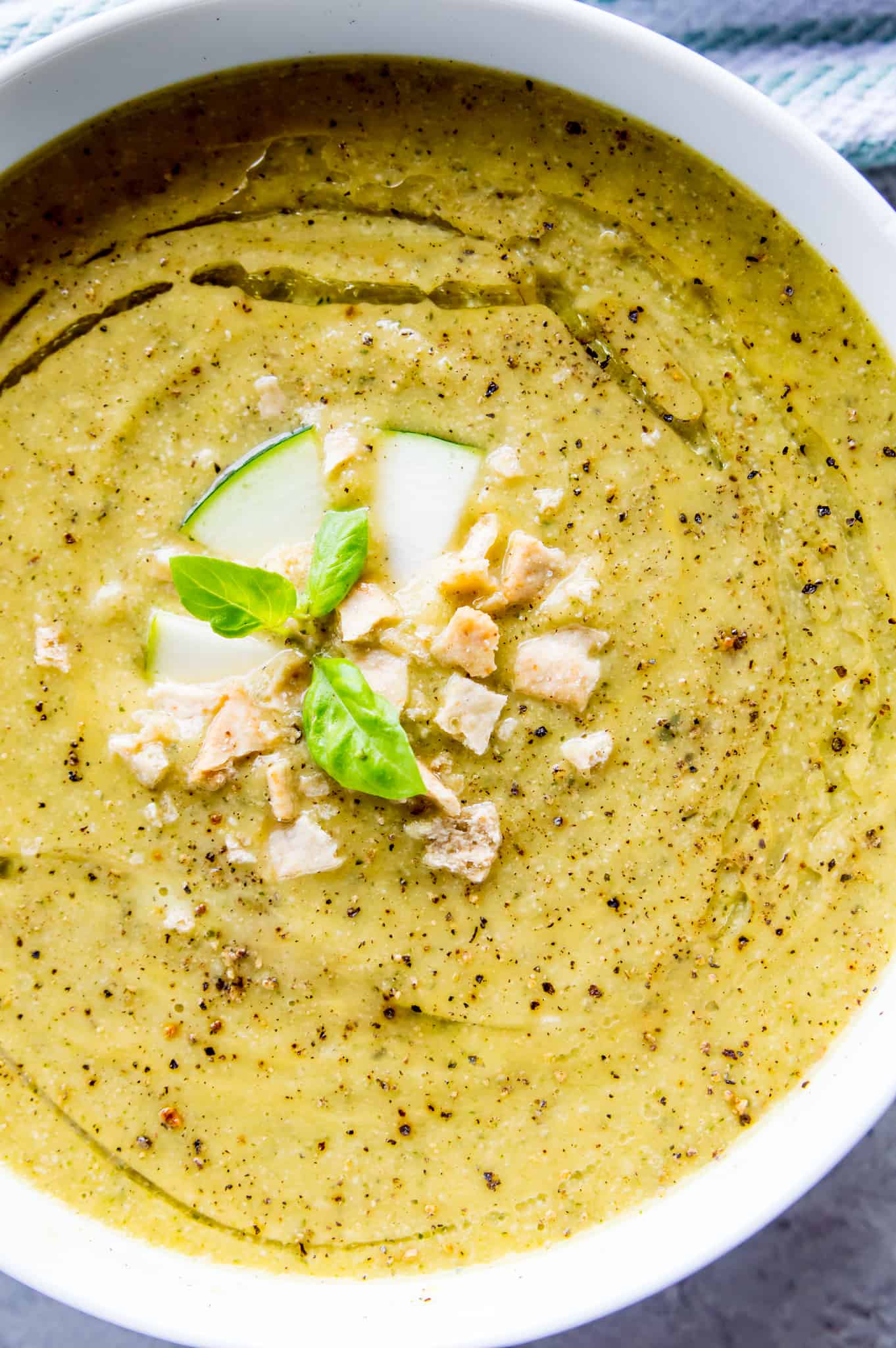 Vegan Zucchini Soup A bowl of creamy vegan zucchini soup topped with crackers, fresh basil and black pepper.