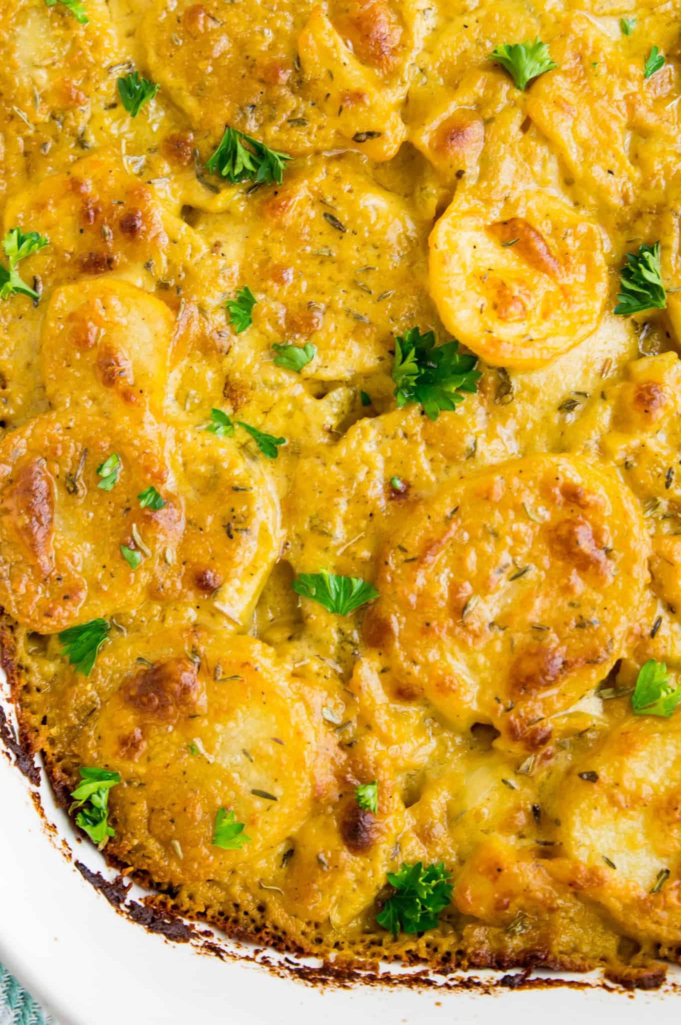 A pan of Whole30 scalloped potatoes garnished with parsley.