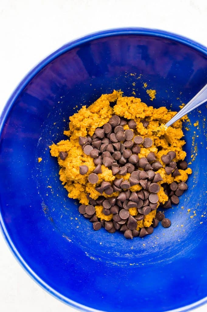 A bowl of edible pumpkin cookie dough with chocolate chips.