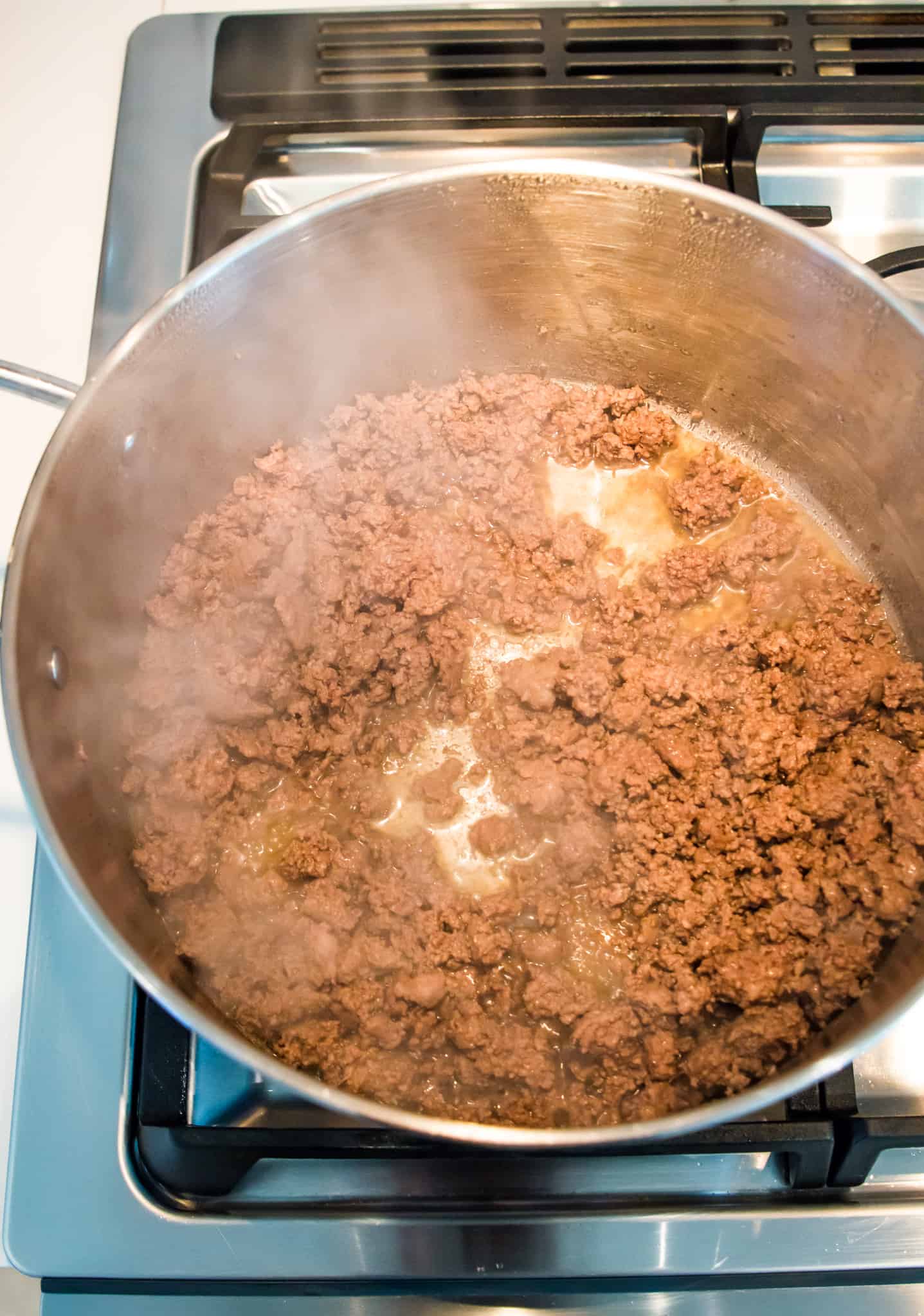 A pot with cooked ground beef in it.