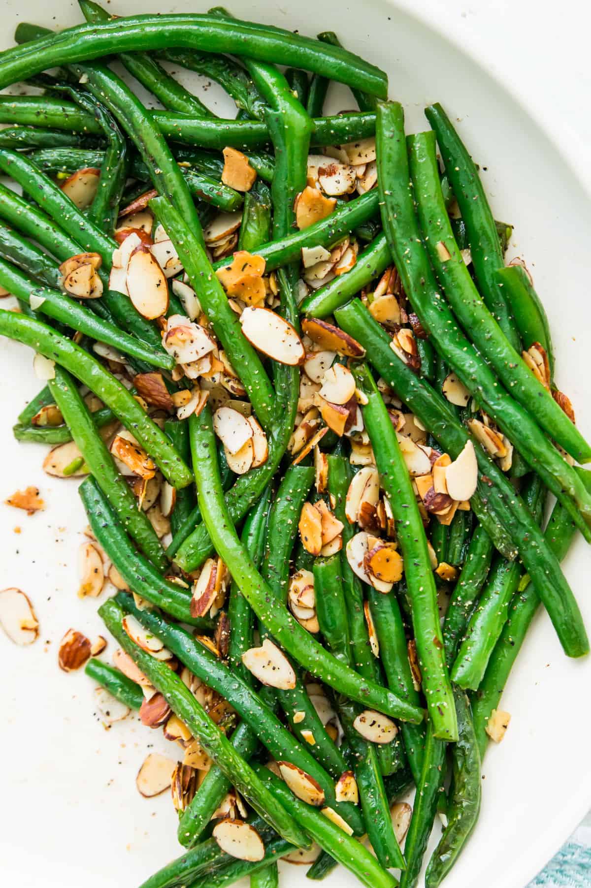 A pan of cooked green beans with roasted slivered almonds.