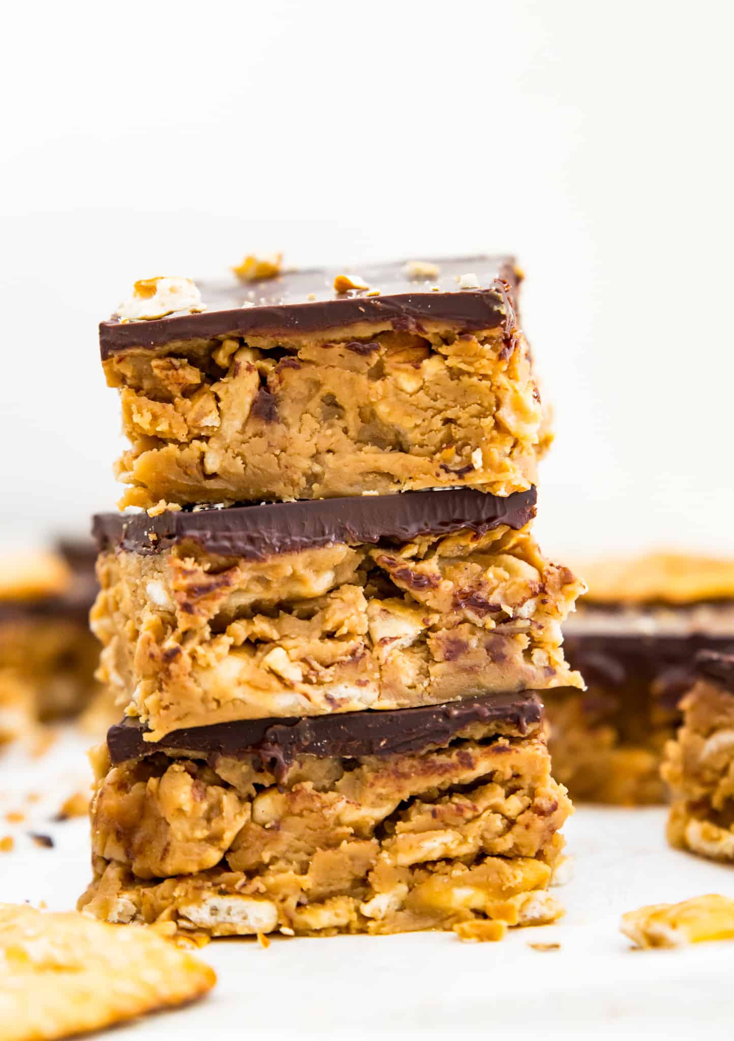 A stack of peanut butter pretzel bars topped with chocolate.