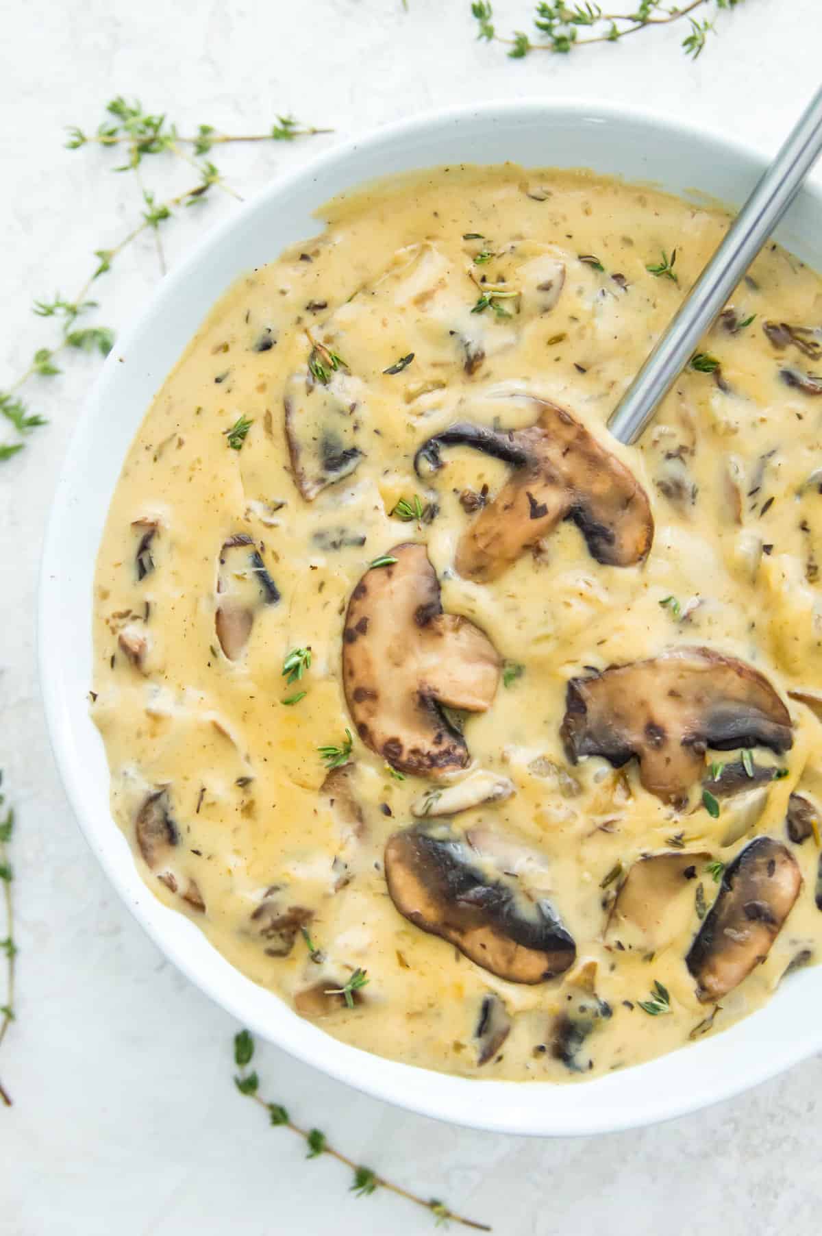 A bowl of Whole30 mushroom soup with a spoon in it.