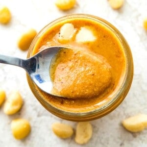 A jar of macadamia nut butter with a spoon in it.