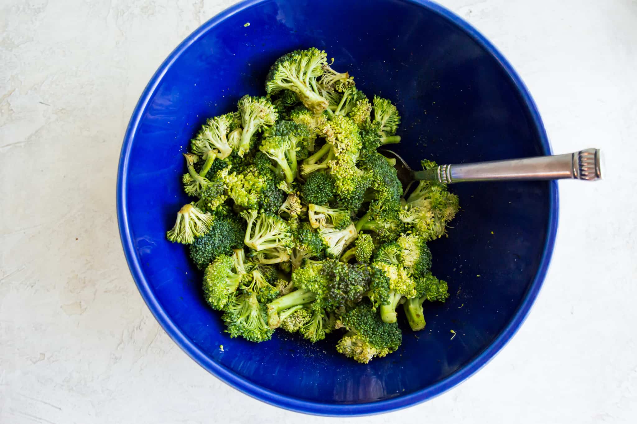 A bowl full of raw cut broccoli.
