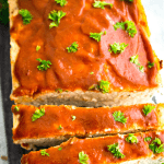 A plate of cut chicken meatloaf garnished with parsley