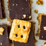 Peanut butter pretzel bars topped with chocolate with a pretzel on top of each piece.