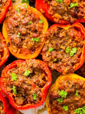 A pan of cooked Whole30 stuffed peppers garnished with fresh parsley.