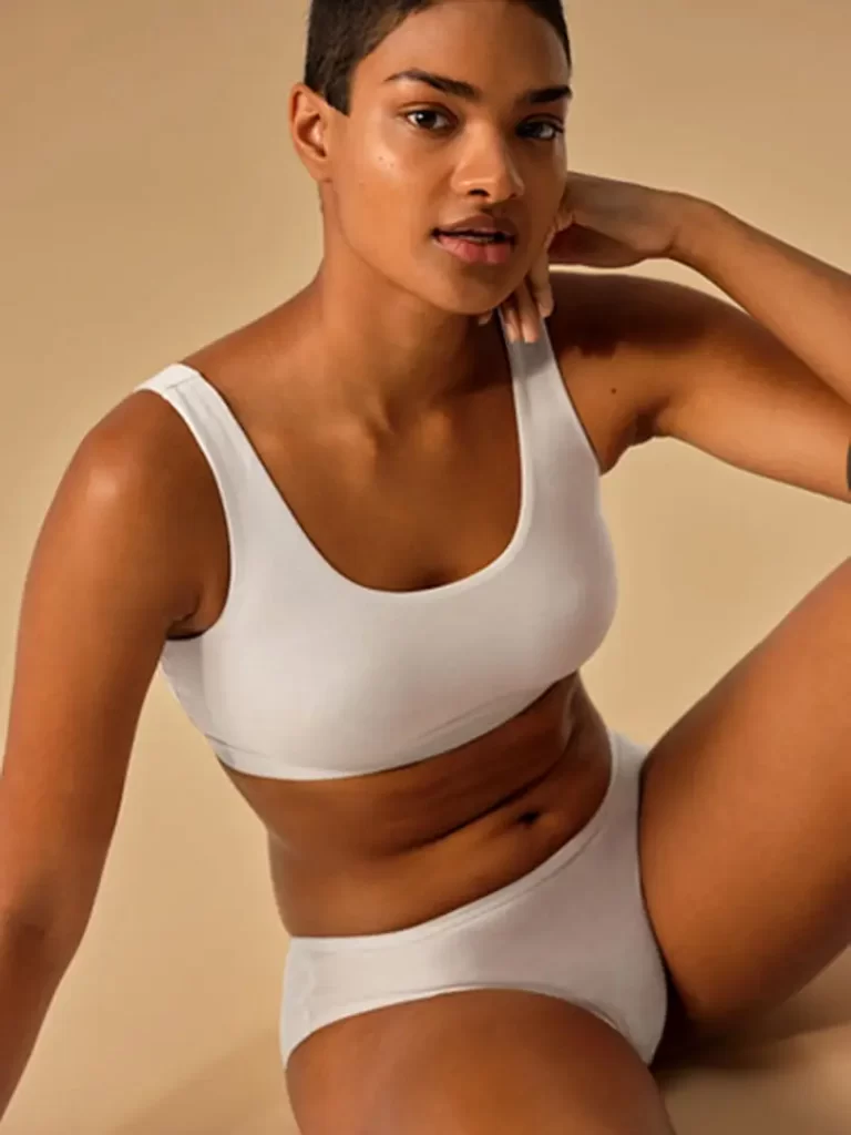 A woman wearing white Allbirds underwear and bra