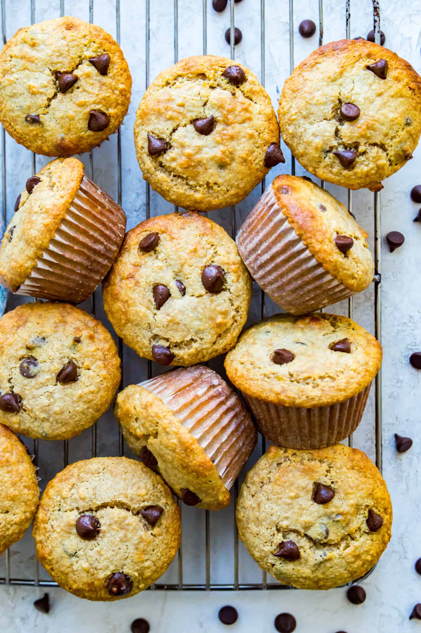 A batch of banana chocolate chip muffins on a baking rack.