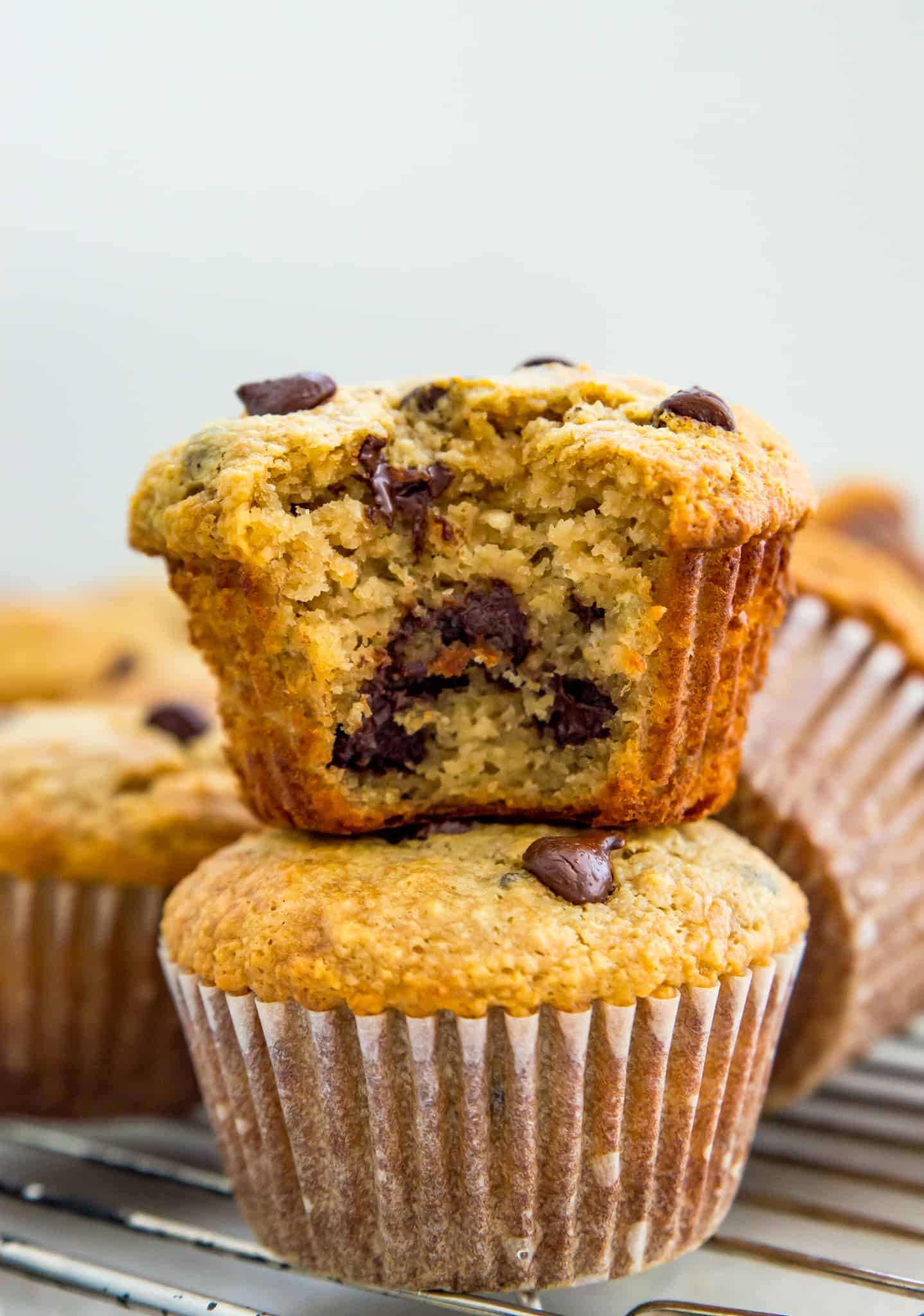 Banana Protein Muffins Recipe Two banana protein muffins stacked on top of each other with a bite out of the top one.
