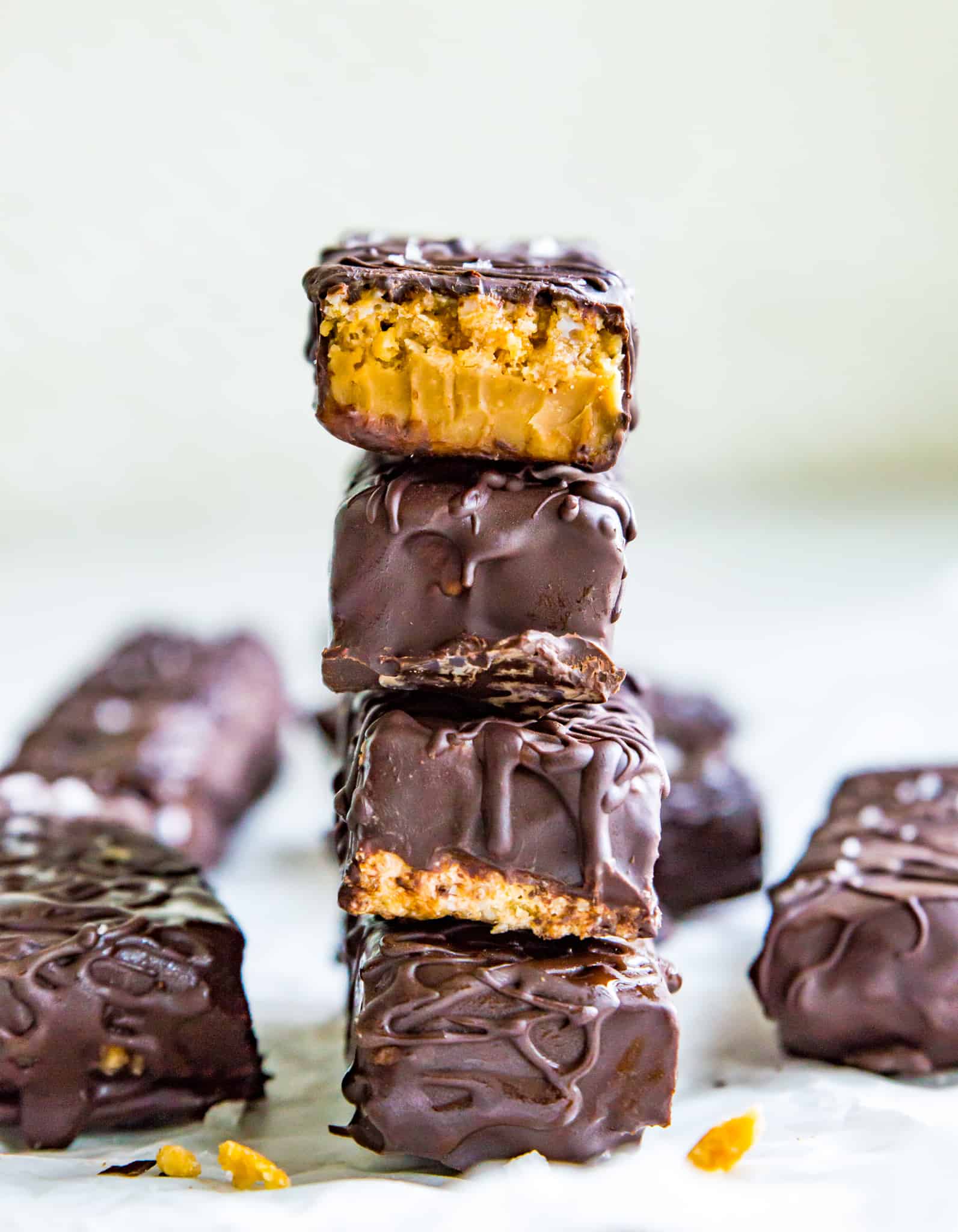 A stack of 4 chocolate peanut butter cereal bars on a piece of parchment paper.