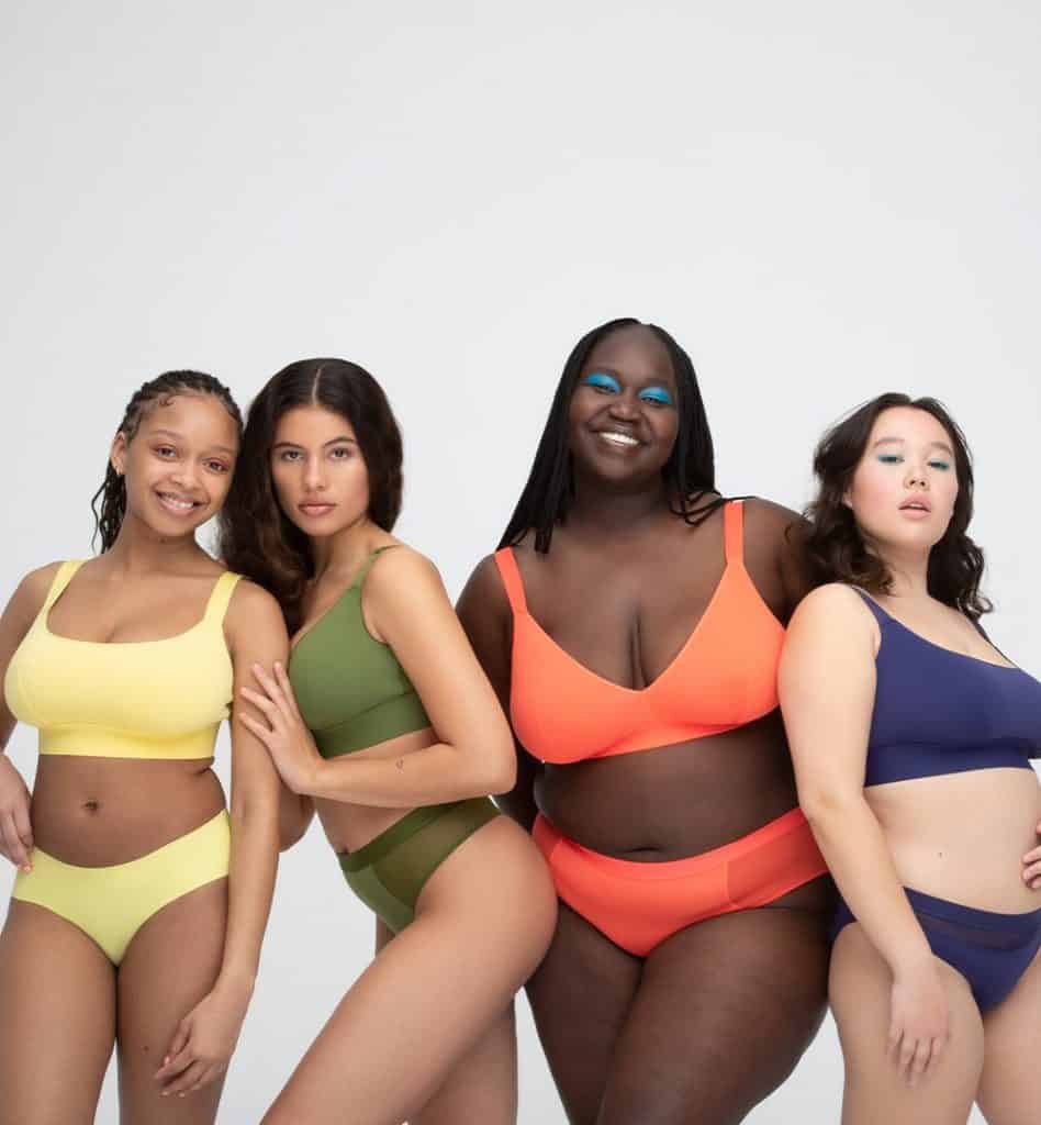 Four women wearing underwear and bras by Parade in different colours including yellow, green, orange and purple.
