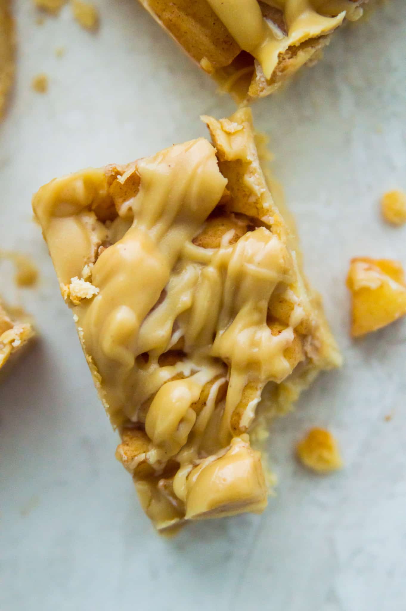 A piece of an apple pie bar with a bite out of it.